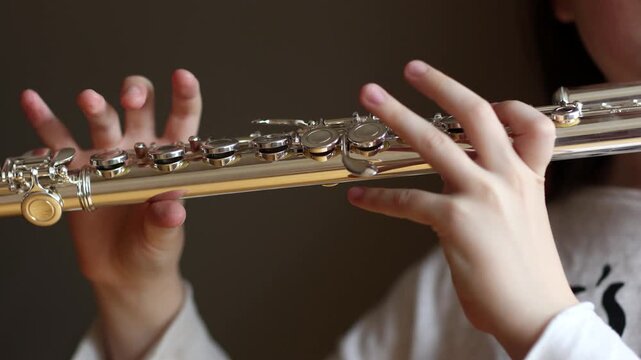 child playing on musical instrument flute close-up. classical music performed by wind instruments.