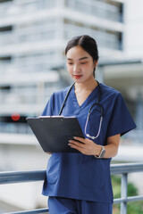 Young doctor reading medical records in hospital corridor