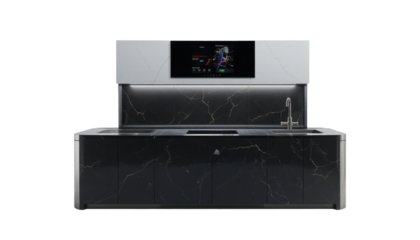 A high-tech kitchen counter setup with subtle under-cabinet lighting and an integrated smart display panel, made from a glossy black solid surface material. It sits on a stark white background.