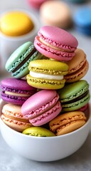 Obraz premium Colorful macarons stacked high in a white bowl, close-up