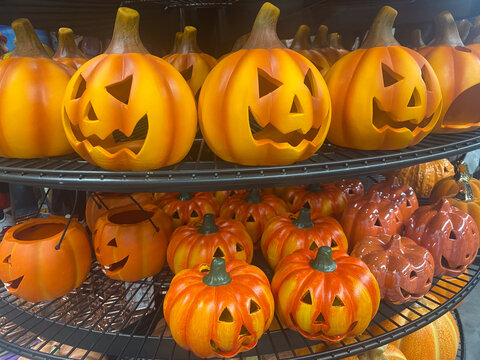 Different orange Halloween pumpkin decorations on the shop shelves