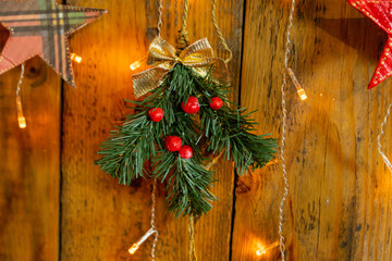 A sprig of a Christmas tree with red berries and a golden bow