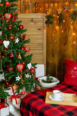 A Christmas tree next to a sofa in the attic
