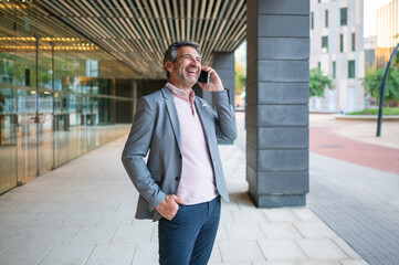 Happy businessman talking on mobile phone outdoors