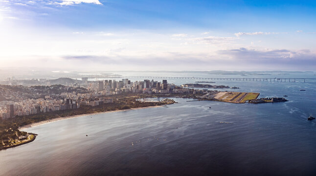 Panoramic sunset view of Rio de Janeiro central coastline, Guanabara Bay, and Santos Dumont Airport runway extending into the water. Rio de Janeiro Brazil.