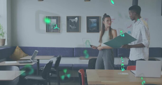 Exchanging glances team reviewing devices and generating floating eco icons while walking