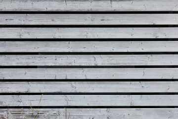 Obraz premium Textured wooden fence with horizontal planks painted in light gray, showcasing natural grain patterns and subtle imperfections, creating a rustic and modern aesthetic