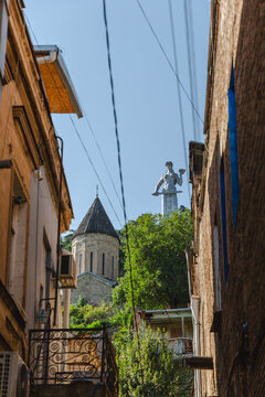 View of the ancient Narikala fortress and the towering Kartlis Deda statue amidst the old buildings, Tbilisi, Tbilisi, Georgia.
