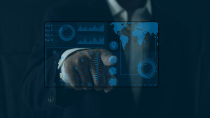 Businessman interacting with futuristic digital interface showing global stock chart, world map, and data analytics, symbolizing global economic strategy and business planning
