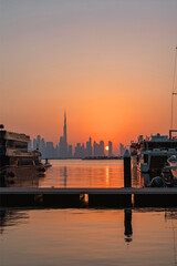 Golden sunset over Burj Khalifa and Dubai Downtown skyline, seen from Dubai Creek Harbour Marina with yachts