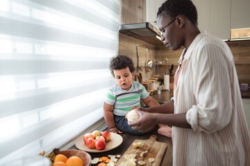 Mother and child preparing healthy fruit snack in kitchen