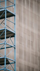 Generative AI blue scaffolding against textured wall background.