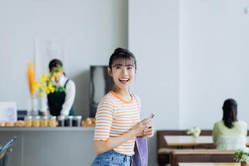カフェに来店する若い女性