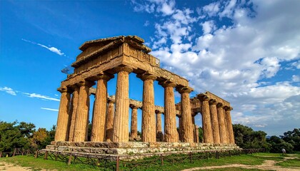 Obraz premium Ancient Stone Temple Ruins Under Blue Sky with White Clouds in Italy