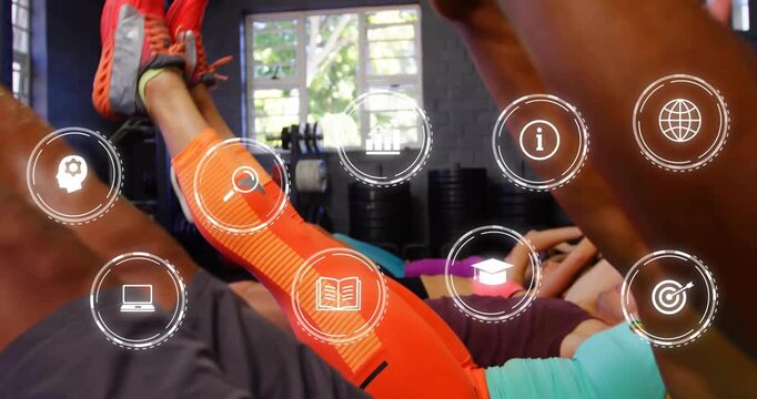Group fitness trainees performing v-up core exercises triggered by app icons overlaying studio mats