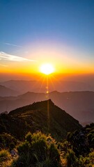 Vibrant sunset over layered mountain ridges, casting a warm glow on the landscape