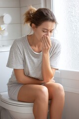 Young Woman Sitting on Toilet with Nausea – Conceptual Photo of Sickness, Discomfort or Stomach Pain