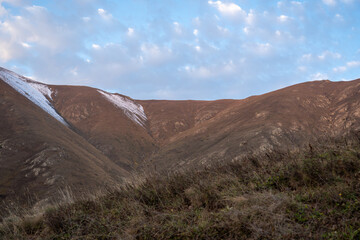 Peaceful mountain slope at sunrise with dramatic cloudscape