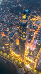 Aerial view of illuminated modern skyscraper with vibrant city lights at dusk - dramatic urban landscape from above