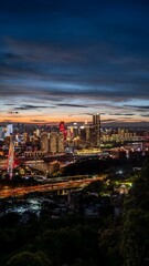 Naklejka premium Chongqing Urban Skyline at Twilight with Illuminated Skyscrapers and Dramatic Cloudy Sky