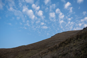 Peaceful mountain slope at sunrise with dramatic cloudscape