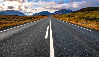 Naklejka premium Asphalt Road Leading to Mountain Range Under Cloudy Sky in Iceland Landscape