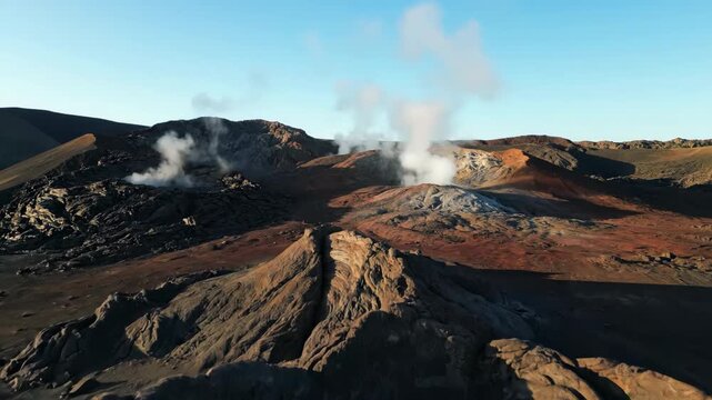 Drone shot slowly descends over a rugged volcanic landscape, showcasing steaming fumaroles and unique geological formations under a clear sky power, grand, primal