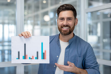 Smiling man presenting business data chart in office