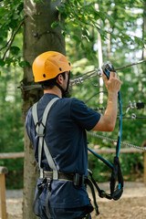 Man checking zipline equipment in forest rope park © EkaZehner