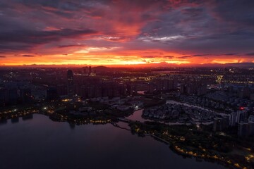 Fototapeta premium Aerial view of Keqiao Shaoxing cityscape at sunset with dramatic fiery sky over waterfront district