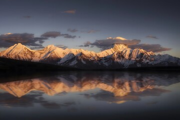 Golden sunset alpine peaks reflecting in calm lake during twilight, western Sichuan China mountain...