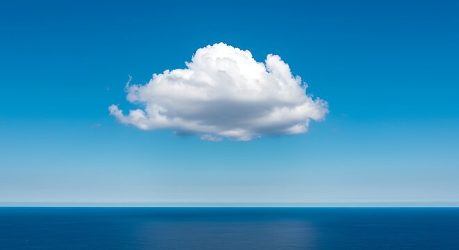 Single white cloud floating above a horizon line on a clear blue sky