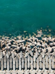 Obraz premium Aerial View Concrete Tetrapod Breakwater Structures Qingdao Coastline Turquoise Ocean Waves Coastal Defense Engineering