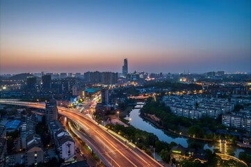 Aerial view of Zhenjiang China city skyline at dusk with illuminated highways flowing through urban...