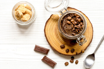 jar with coffee-chocolate body scrub top view wooden background