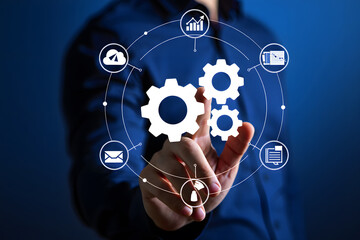 Fototapeta premium Hand touching digital network of gears and icons representing business processes