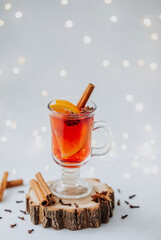Warm winter mulled wine in glass with orange slice cinnamon stick and star anise on wood