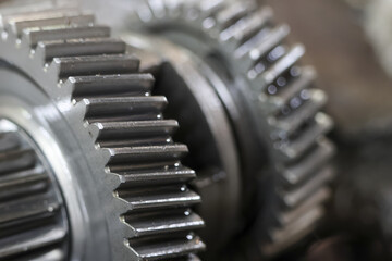 Close up of metallic gears, highlighting their interlocking teeth and intricate design, evoking...