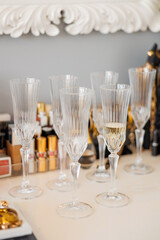 Elegant crystal champagne glasses arranged on a table, reflecting light with sparkling details, perfect for wedding reception, celebration or luxury event atmosphere