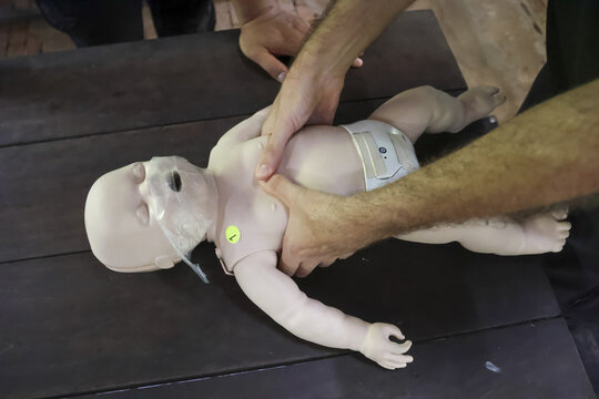 Infant CPR training demonstration showing gentle chest compressions for resuscitation, emphasizing life saving skills and emergency preparedness resuscitation infant baby training medical health - Powered by Adobe