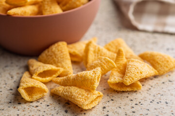Bugles snack. Cone corn chips on kitchen table.