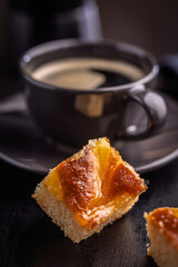 Catalana sponge cake and coffee cup on black table.