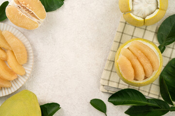 Fresh pomelo fruit with leaf on white table background.