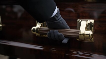 Man in Grey Gloves Carries Wooden Coffin at a Funeral Procession