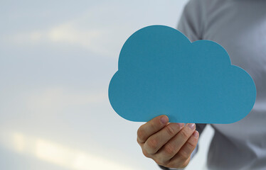 Image of a hand holding a blue cloud shape.  Perfect for cloud computing, data storage, ideas, and technology concepts.