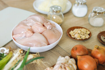 Fresh Chicken Breasts Ready To Cook With Onions, Garlic And Spices On Wooden Surface