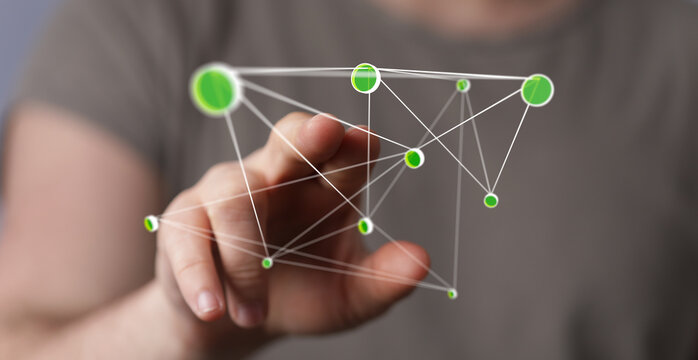 Person's finger touching a network of green nodes.  Illustrates connectivity, technology, and growth.