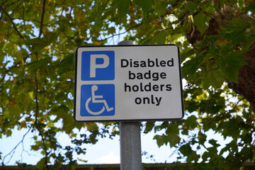 Disabled badge holders only sign for parking space in the UK. restrictive parking zone