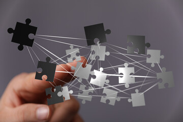 Conceptual image featuring hand connecting puzzle pieces, symbolizing teamwork, network, and collaborative solutions. Ideal for business, techno