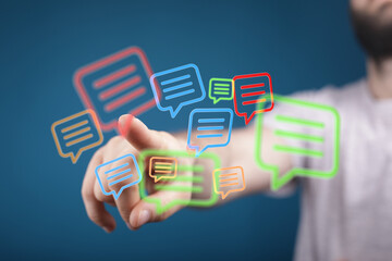 A man interacts with holographic speech bubbles showcasing digital connection and communication. Modern network technologies are shown.